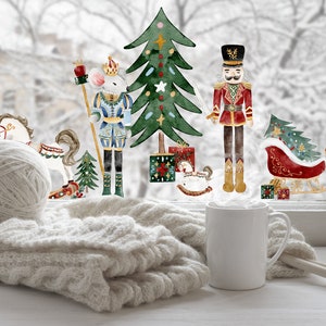 Puede incluir: Una acogedora escena invernal con una bola de hilo blanco, una manta de punto y una taza blanca. En el fondo, recortes de acuarela de un árbol de Navidad, cascanueces y un trineo. Agujas de tejer junto a la taza.