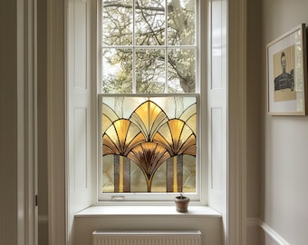 May include: A stained glass window film with a geometric design in shades of gold, brown, and white. The film is installed in a window with a white frame and a view of trees outside.