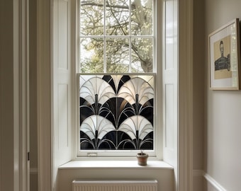 May include: A white window with a black and white geometric stained glass design. The window is set in a white frame and has a white windowsill. A small potted plant sits on the windowsill.