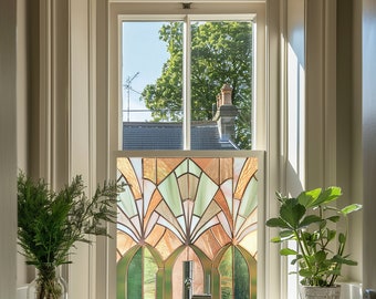 May include: A stained glass window with a geometric design in shades of green, brown, and orange. The window is set in a white frame and is surrounded by white trim.