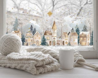 Könnte beinhalten: Winterliche Szene mit einer weißen Tasse, Stricknadeln und einem Wollknäuel auf einer Fensterbank. Eine Strickdecke ist über die Fensterbank drapiert. Das Fenster zeigt ein Aquarell eines verschneiten Dorfes mit beleuchteten Fenstern und einem goldenen Stern.