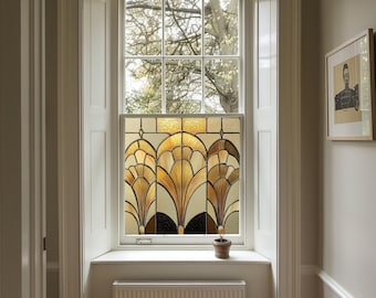 May include: A window with a stained glass design featuring a geometric pattern of gold and brown leaves. The window is framed in white and has a white windowsill. A small potted plant sits on the windowsill.