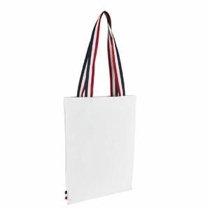 Peut inclure: Sac fourre-tout en toile blanche avec des anses rayées rouge, blanc et bleu.