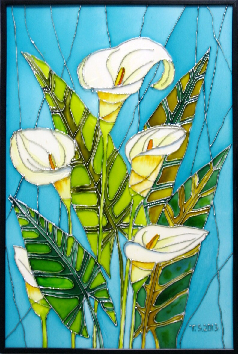 May include: A stained glass artwork featuring white calla lilies with green leaves on a blue background. The artwork is signed "T.S. 2013" in the bottom right corner.