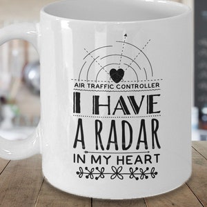 May include: White ceramic mug with a black graphic design. The design features a radar screen with a heart in the center and the text "Air Traffic Controller I Have A Radar In My Heart".
