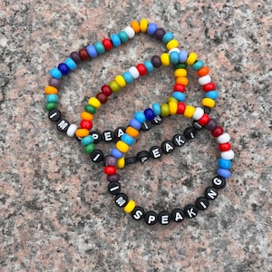 Puede incluir: Pulseras de cuentas multicolores con las palabras "I'm Speaking" escritas en letras negras.