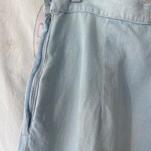 May include: A light blue denim skirt with a zipper on the side.