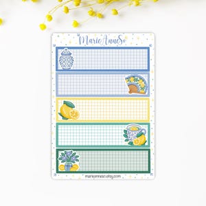 May include: A decorative sticker sheet with five rectangular sections, each with a grid pattern. The sections are bordered in blue, yellow, and green, and feature illustrations of a vase, fan, lemon, teacup, and flowers. The text "MarieAnneSo" and "marieanneso.etsy.com" are also present.