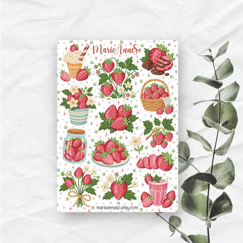 May include: A sheet of strawberry-themed stickers with various illustrations. The designs include strawberries, strawberry plants, ice cream, a basket of strawberries, and a jar of strawberries. The text "MarieAnneSo" and a website address are also visible.