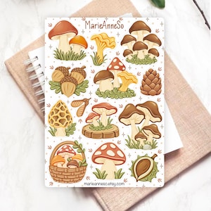 Può includere: Un foglio di adesivi con varie illustrazioni di funghi, ghiande, una pigna, una castagna e un cestino pieno di funghi. Il testo MarieAnneSo e marieanneso.etsy.com è stampato sul foglio, decorato con piccoli dettagli a forma di stella.
