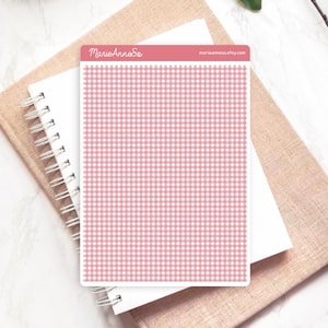 Peut inclure: Une feuille d'autocollants avec un motif vichy rose et blanc. La feuille est rectangulaire avec des coins arrondis. Le texte "MarieAnneSo" et "marieannes.etsy.com" est visible en haut. Elle est posée sur un carnet à spirales blanc et un carnet beige.