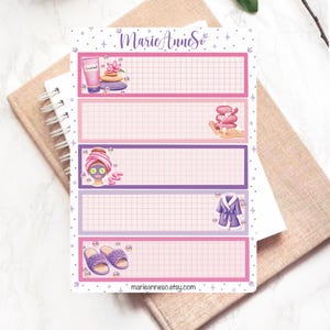 May include: A planner sticker sheet with spa-themed illustrations. The sheet features pink and purple boxes with grid lines, and images of spa products like a face mask, lotion, and slippers. The text "Marie Anne So" and "marieanneso.etsy.com" are also visible.