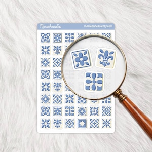 Peut inclure: Une feuille d'autocollants décoratifs bleus et blancs avec divers motifs floraux et géométriques. Une loupe met en évidence trois autocollants. Le texte "MarieAnneSo" et "marieanneso.etsy.com" sont visibles.