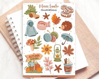 Op de afbeelding: Een vel stickers met herfstthema illustraties. De stickers bevatten een egel, een paddenstoel, een lantaarn, een bloem, een sjaal, een kopje pompoensoep, een bordje met de tekst "Herfsttuin", en meer.