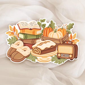 Peut inclure: Une illustration autocollante montrant une pile de livres, une caisse en bois avec des citrouilles orange et blanches, un gâteau avec un glaçage blanc sur un plat, des chaussons marron à doublure polaire et une radio vintage.