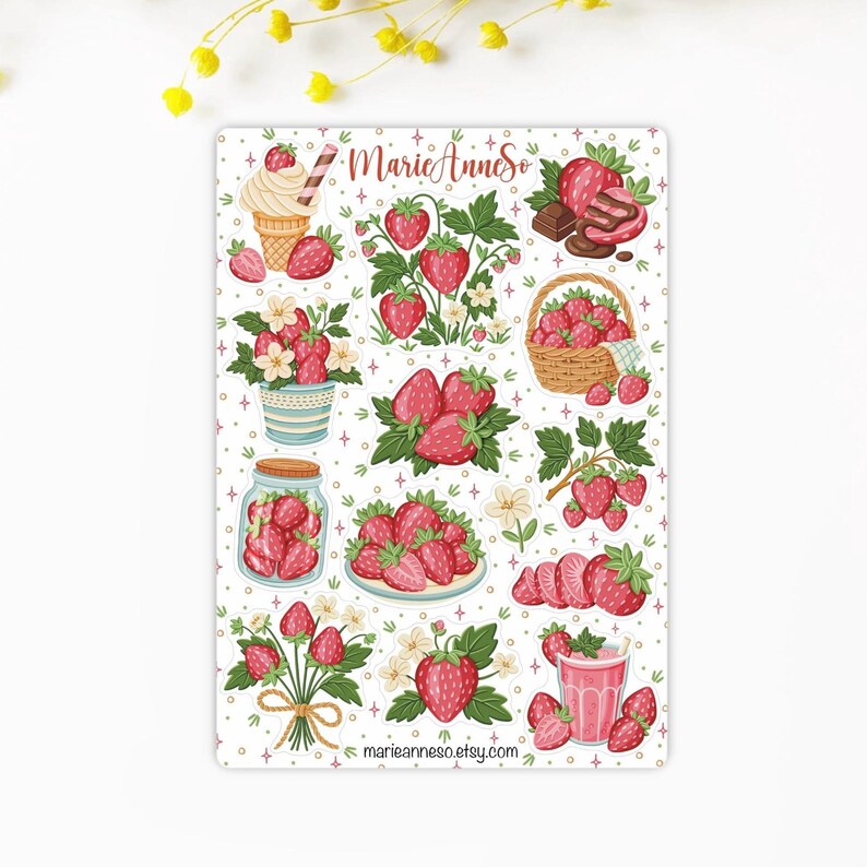 May include: A sticker sheet featuring various illustrations of strawberries. Designs include strawberries in a basket, a jar, and a glass, along with strawberry plants and a strawberry ice cream cone. The text "MarieAnneSo" and a website address are also included.