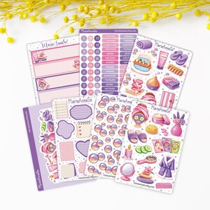 May include: A selection of planner stickers with spa and self-care themes. The stickers depict illustrations of face masks, bath products, and relaxation items in pink, purple, and white. The brand name "MarieAnneSo" is visible on the stickers.