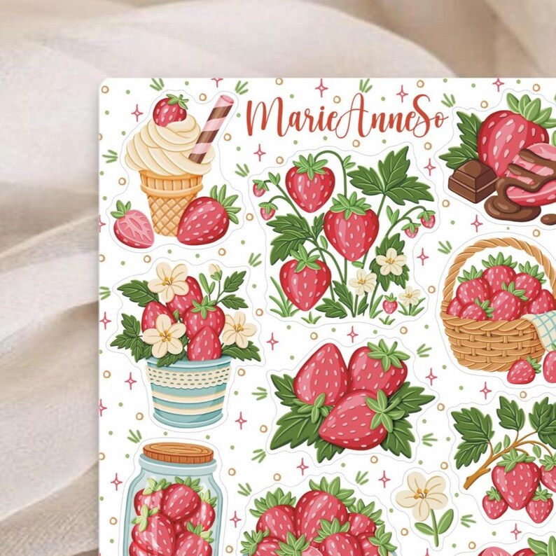 May include: A sheet of stickers featuring various strawberry-themed illustrations. Designs include strawberries, ice cream cones, chocolate-covered strawberries, and strawberries in a basket and a jar. The text "MarieAnneSo" is also present.