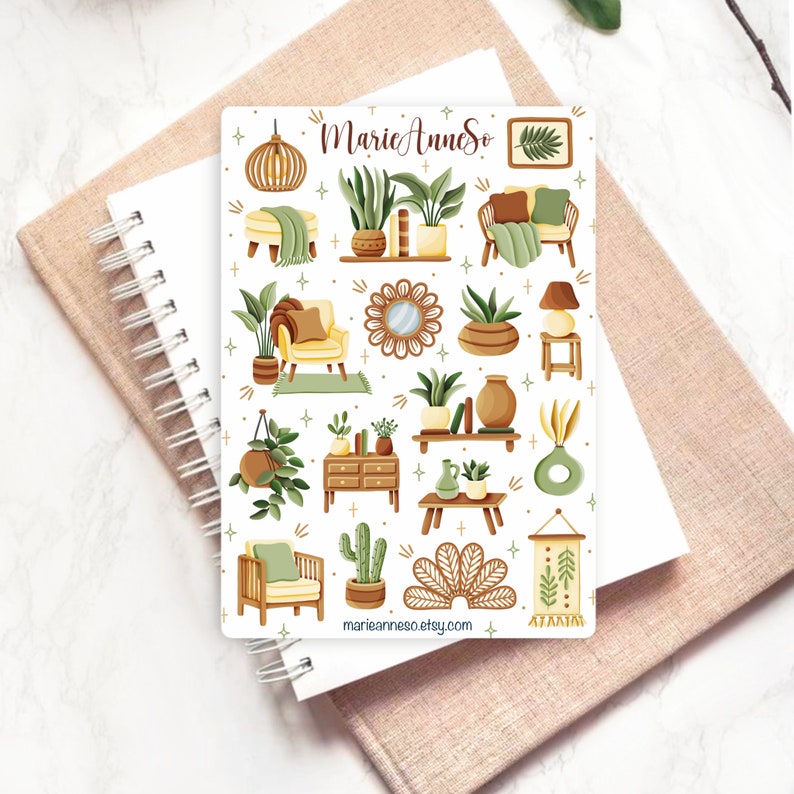 May include: A sheet of stickers featuring illustrations of home decor items in a boho style. The stickers include plants, furniture, lamps, and other decorative elements. The stickers are white with a light brown background and feature a variety of green, brown, and yellow colors.