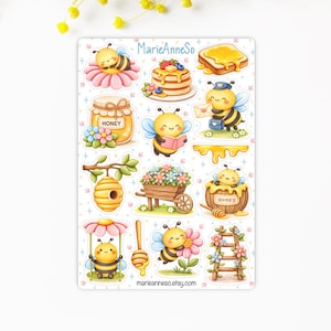 Peut inclure: Une planche d'autocollants avec des illustrations d'abeilles, de miel et d'objets connexes. Les motifs comprennent des abeilles sur des fleurs, des pots de miel, des crêpes et une cuillère à miel. Le texte "MarieAnneSo" et "marieanneso.etsy.com" sont également visibles.