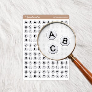 Peut inclure: Une feuille d'autocollants alphabet avec une loupe. Les autocollants sont des cercles blancs avec des lettres noires. La loupe montre les lettres A, B et C. Le texte "MarieAnneSo" et "marieanneso.etsy.com" sont visibles.
