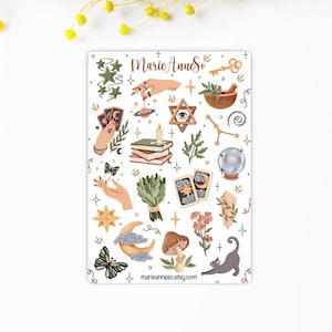 Puede incluir: Una hoja de pegatinas con varias ilustraciones m&iacute;sticas que incluyen manos, cartas del tarot, una bola de cristal, una luna creciente, un hongo, un gato, estrellas, plantas y un mortero. El texto MarieAnneSo y marieanneso.com est&aacute; impreso en la hoja.