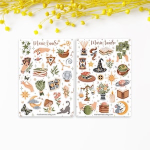 Peut inclure: Deux planches d'autocollants étiquetées MarieAnneSo présentant diverses illustrations incluant des mains, des cartes de tarot, des cristaux, une boule de cristal, un chapeau de sorcière, des livres, un chat, une souris, des plantes, des étoiles, des lunes et des éléments célestes dans des tons terreux et des accents dorés.