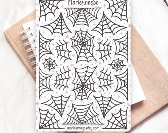 May include: A rectangular sticker sheet featuring various black spider web illustrations on a white background. The sheet includes the text MarieAnneSo at the top and marieanneso.etsy.com at the bottom, accented with small purple star icons.