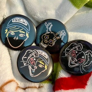 May include: Four black and white button pins with neon outlines. The pins feature a character with a security hat, a skull with antlers, and a cat with a stitched eye.