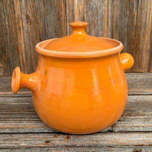 Op de afbeelding: Een witte keramische mok met een zwart handvat en de tekst "But First, Coffee" in een vetgedrukte, zwarte letter. De mok staat tegen een vage achtergrond, wat het strakke ontwerp benadrukt.