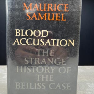 Pode incluir: Um livro de capa dura intitulado "Blood Accusation" de Maurice Samuel. A capa é principalmente preta com o título e o nome do autor em letras laranja e brancas. O subtítulo diz "The Strange History of the Beiliss Case."