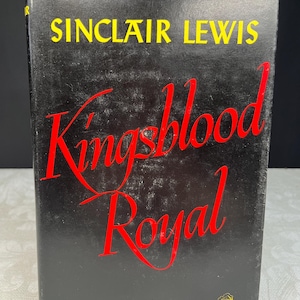 Może przedstawiać: Twarda oprawa książki z czarną okładką z tytułem "Kingsblood Royal" w czerwonym skrypcie. Nazwisko autora, "Sinclair Lewis", jest w żółtych literach blokowych u góry. Książka jest powieścią Random House.