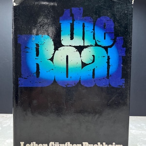 May include: A book cover featuring the title "The Boat" in blue and white, set against a black backdrop. The author's name, Lothar-Günther Buchheim, and the subtitle "A Novel" are in white text at the bottom. The cover also states the book is about a German submarine in World War II.
