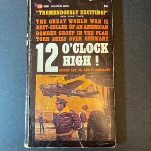 Puede incluir: Portada de libro de bolsillo vintage de "12 O'Clock High!" de Beirne Lay Jr. y Sy Bartlett. La portada presenta una pintura de bombarderos y tripulación de la Segunda Guerra Mundial, con texto como "Tremendously Exciting!".