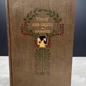 Peut inclure: Livre à couverture rigide, "Tommy and Grizel" de J.M. Barrie. La couverture marron clair est ornée de feuilles vertes et de baies rouges. Le titre et le nom de l'auteur sont en lettres dorées.