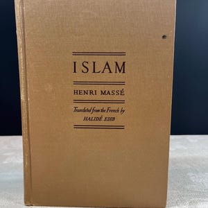 May include: A hardcover book titled "ISLAM" by Henri Massé, translated from French by Halidé Edib. The book has a tan cover with the title and author's name in dark brown lettering. The book is standing upright.