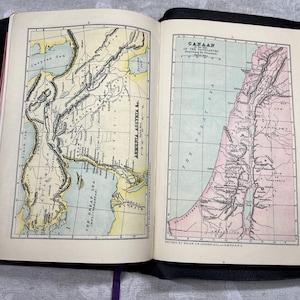 Puede incluir: Libro abierto con dos mapas antiguos detallados. La p&aacute;gina izquierda muestra un mapa de Armenia y Asiria, mientras que la p&aacute;gina derecha muestra un mapa de Cana&aacute;n. Ambos mapas est&aacute;n coloreados con tonos de amarillo, verde y rosa, con etiquetas de texto.