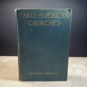May include: A dark teal hardcover book titled Early American Churches by Aymar Embury II. The front cover features gold lettering with the title centered at the top and the author's name printed in smaller gold text at the bottom of the book.