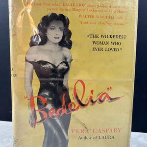 May include: A yellow book cover with a black and white illustration of a woman in a black dress. The title of the book is "Bedelia" in red and black lettering. The text on the cover reads "The book from which EAGLE-LION Films produced the motion picture starring Margaret Lockwood and Ian Hunter. WALTER WINCHELL calls it, "Taut and thrilling cinema." "THE WICKEDEST WOMAN WHO EVER LOVED" VERA CASPARY Author of LAURA"