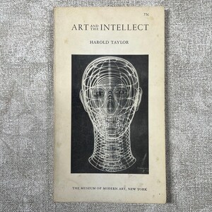 May include: A vintage softcover book titled Art and the Intellect by Harold Taylor, published by The Museum of Modern Art, New York. The off-white cover features a black rectangular inset with a white wireframe illustration of a human head.