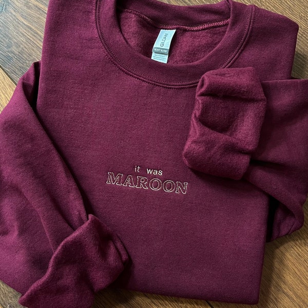 il s'agissait d'un sweat-shirt ou d'un t-shirt brodé à col rond bordeaux d'inspiration taylor swift