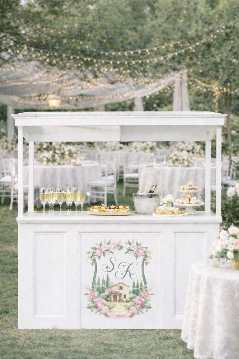 Outdoor wedding bar decorated with personalized watercolor crest monogram featuring florals, initials and romantic venue artwork.