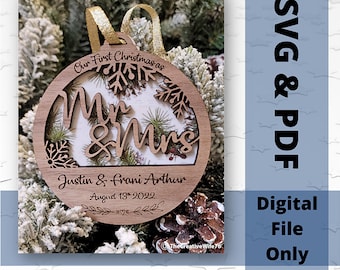 Puede incluir: Un adorno navideño de madera con un diseño recortado de "Mr & Mrs" y copos de nieve. El adorno está personalizado con los nombres "Justin & Frani Arthur" y la fecha "August 13, 2022".