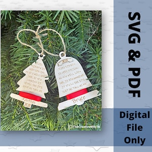 Peut inclure: Deux décorations de Noël en bois, l'une en forme de sapin de Noël et l'autre en forme de cloche, avec un ruban rouge et un texte personnalisé. Le texte sur l'ornement de l'arbre dit "THIS RIBBON IS VERY SPECIAL, AS YOU WILL SEE, IF YOU UNWIND IT YOU'LL SEE IT'S JUST AS TALL AS ME" et "Kaitlyn 2021". Le texte sur l'ornement de la cloche dit "THIS RIBBON IS VERY SPECIAL AS YOU WILL SOON SEE, IF YOU UNWIND IT YOU'LL SEE IT'S JUST AS TALL AS WE" et "Bryce".