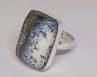 May include: A silver ring with a white and gray dendritic agate stone. The stone is rectangular and has a unique pattern of black dendrites.