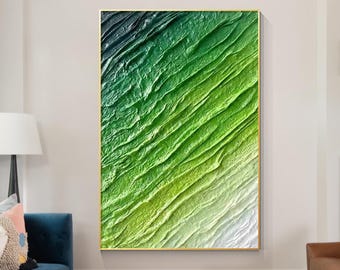 May include: Abstract painting with a green and white color gradient. The painting features a textured, layered effect, resembling waves or ripples. The painting is framed in a gold frame and is hanging on a white wall.