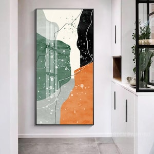 Könnte beinhalten: Abstrakter Kunstdruck mit schwarzem Rahmen. Das Kunstwerk zeigt eine vertikale Komposition mit einer Mischung aus Farben, darunter Grün, Orange, Schwarz und Weiß. Es kombiniert geometrische Formen und Spritzfarbeneffekte mit dünnen schwarzen Linien.