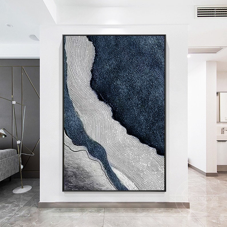 Pu&ograve; includere: Una grande opera d'arte murale rettangolare caratterizzata da una composizione astratta ad alto contrasto. Il dipinto mostra aree testurizzate blu navy profondo accanto a sezioni di vernice grigio chiaro applicate in linee sottili, parallele, ondulate e verticali.