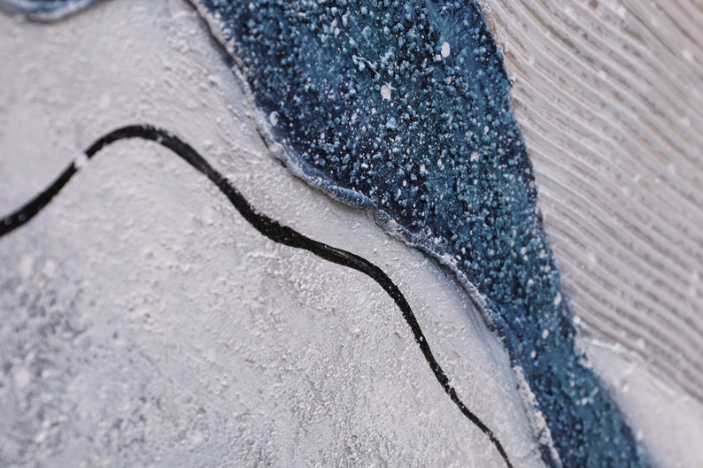 Pu&ograve; includere: Un dipinto astratto materico caratterizzato da uno spesso strato di vernice blu scuro dalla superficie granulosa, in contrasto con un'area grigio chiaro liscia con striature orizzontali e una sottile linea ondulata nera dipinta a mano.