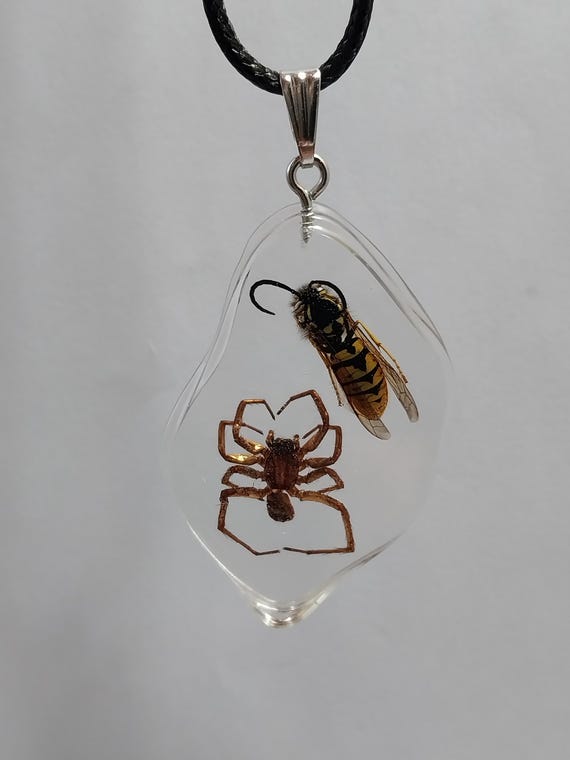 A real wasp and spider preserved in resin and worn as jewelry — gothic taxidermy you can actually put on your body.
